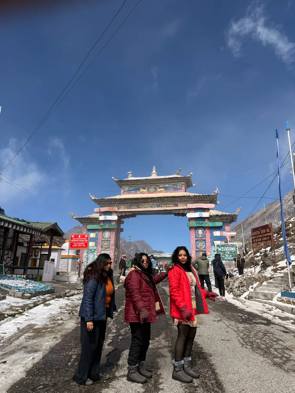 Travellers at the snow-covered Tawang welcome gate
